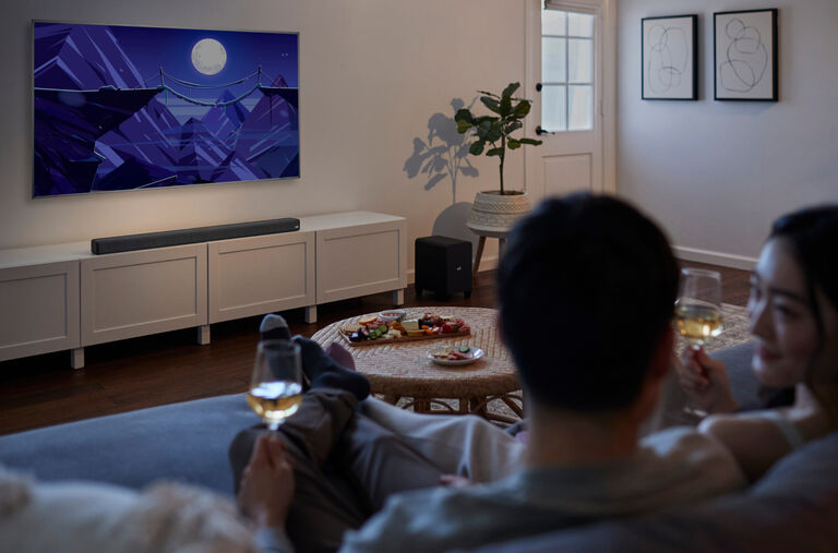 A couple watching TV and drinking wine. A couple watching TV and drinking wine.